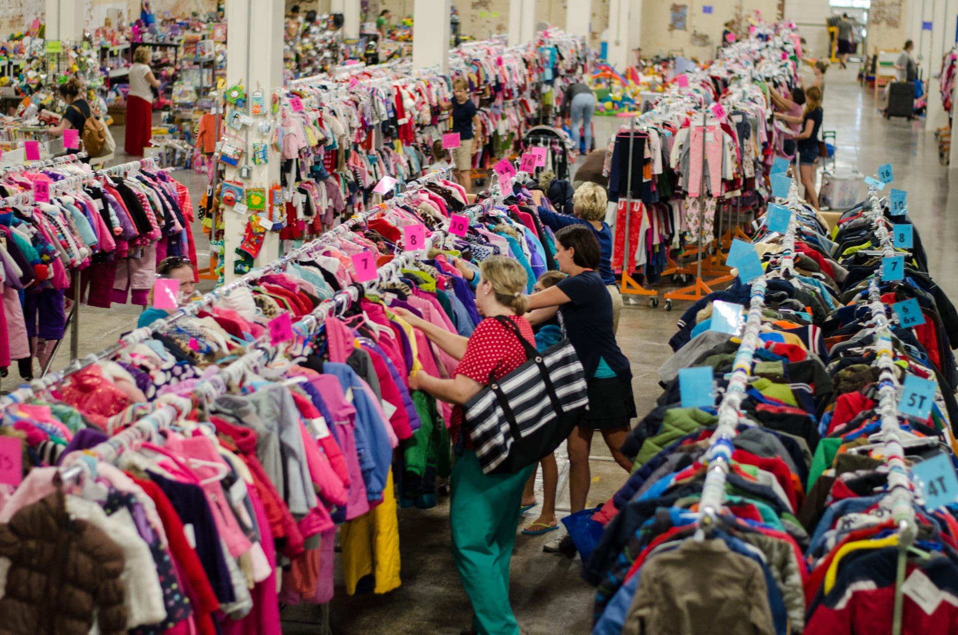 Shoppers browsing racks at a high-volume consignment sale